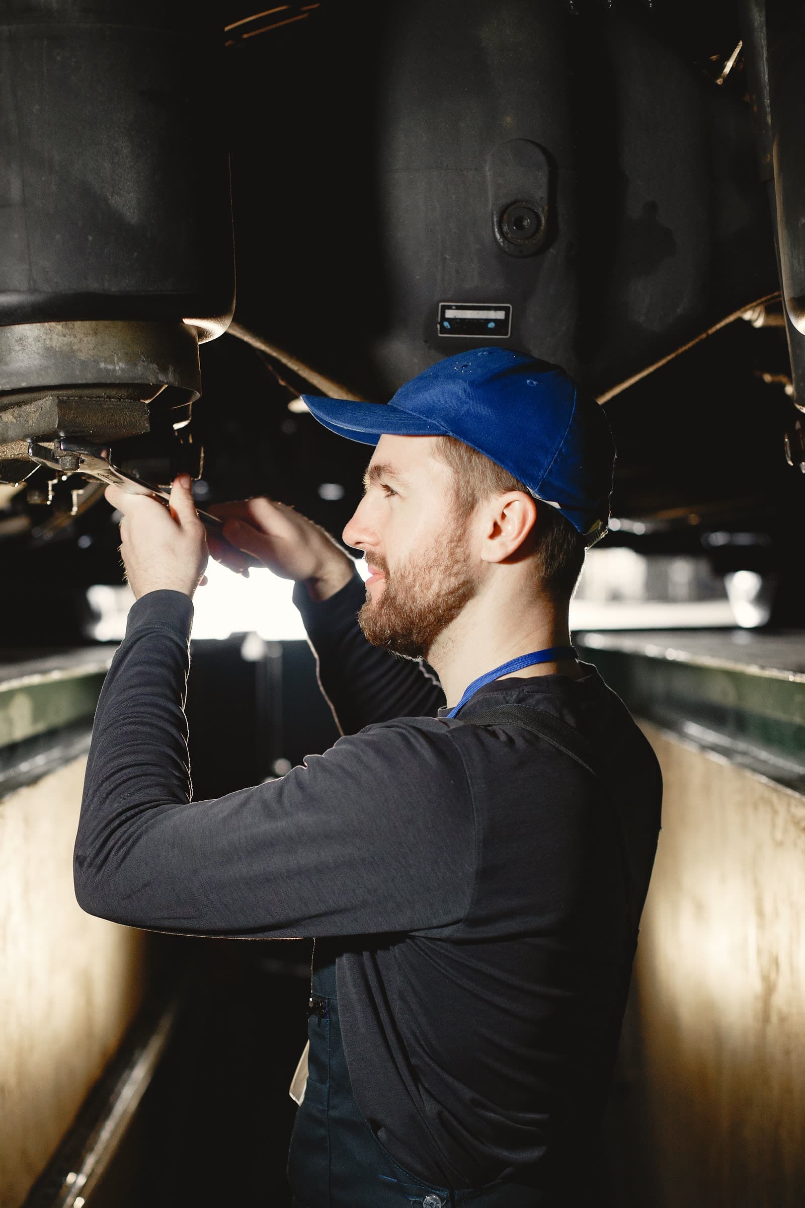 A mechanic working under a car in a workshop pit